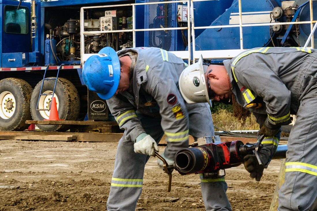 Bullet Wireline crew handling downhole tools at the wellhead
